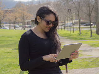 Fototapeta premium Retrato de mujer trabajando desde su tablet en la paz de la naturaleza, primer plano.