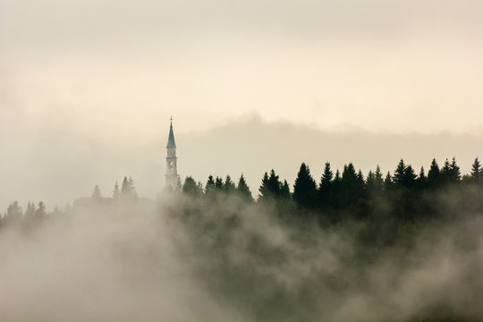 Church, Roana, Altopiano of Asiago, Province of Vicenza, Veneto, Italy. Steeple in the mist.