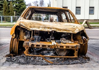 Burnt car is on the asphalt road