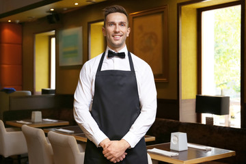 Handsome young waiter at restaurant