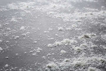 Fototapeta na wymiar White flour on dark background, closeup