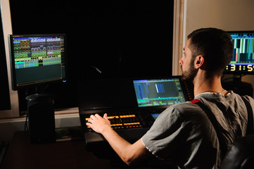 A lighting engineer works with lights technicians control on the concert show. Professional light...