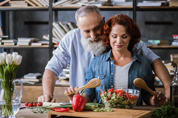Couple cooking vegetable salad