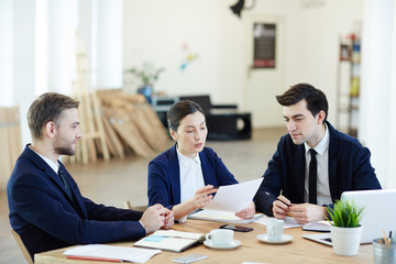 Young colleagues gathered by workplace for start-up meeting