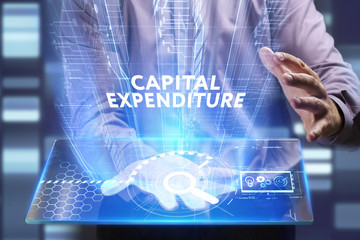 Business, Technology, Internet and network concept. Young businessman working on a virtual screen of the future and sees the inscription: Capital expenditure