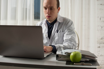Doctor filling medical online form in the laptop tablet. The works at the hospital