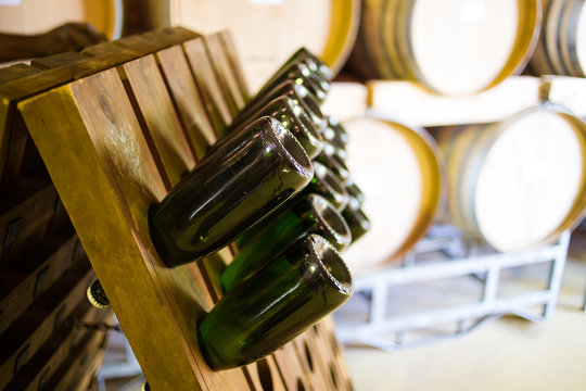 Close up image of lots of champagne bottles in a bottle rack in a wine cellar