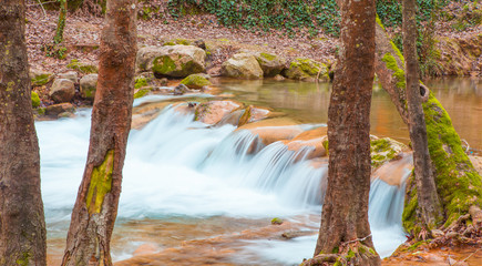 Fototapeta na wymiar Closeup view of little waterfall on the river