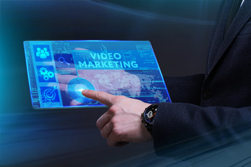 Business, Technology, Internet and network concept. Young businessman working on a virtual screen of the future and sees the inscription: Video marketing
