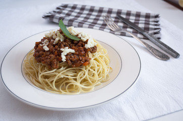 spaghetti Bolognese on the white plate with mozarella and basil