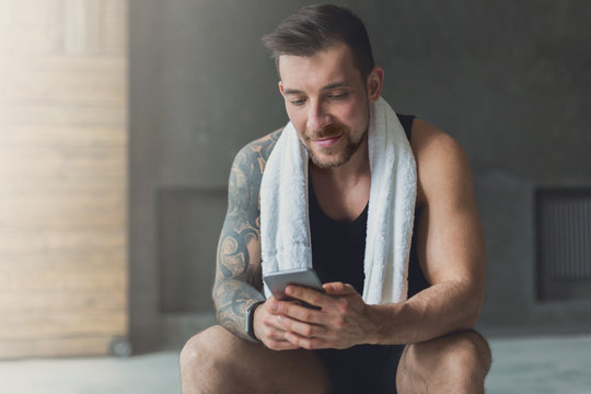 Handsome Man Use Mobile Phone In Gym