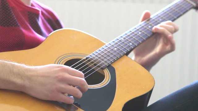 Hipster guy plays acoustic guitar. Slow motion. Music, Sound, Band, Concept.