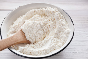 Making dough, baking. Bowl with flour on wood desk