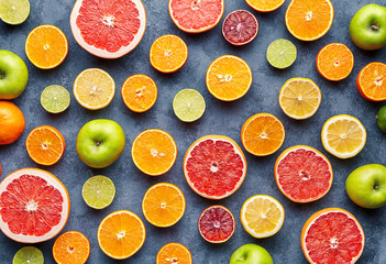 Organic fruit food background. Citrus fruit pattern on grey concrete table. Healthy eating and diet. Antioxidant, detox, dieting, clean eating, vegetarian, vegan, fitness or healthy lifestyle concept