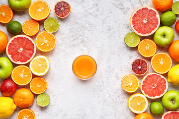 Smoothie or fresh juice in citrus fruits background flat lay, healthy lifestyle vegetarian organic antioxidant detox diet. Tropical summer assortment mix grapefruit, orange, apple, mandarin