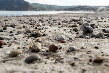 Einsamer Sandstrand mit großen bunten Steinen
