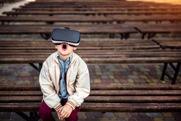 Little boy in virtual reality glasses in the park