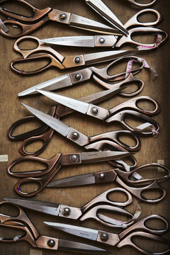 Row of used and worn scissors on tabletop