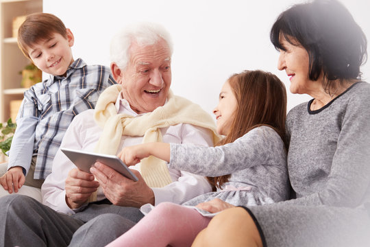 Grandchildren and grandparents using a tablet