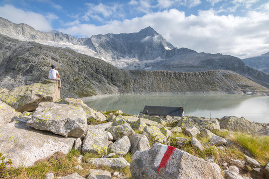 Hicker admire the Adamello Mount and Garibaldi refuge. Tem&Atilde;&sup1;, Val d'Avio (Adamello Park), Brescia province, Lombardy, Italy, Europe