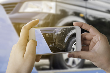 Young women using smart phones to take photos of accident insurance claims.