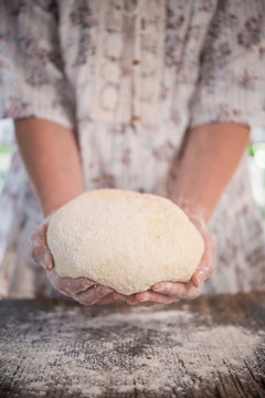 Female hands holding dough