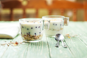 Morning granola with yogurt and berries on wooden kitchen table. Concept healthy breakfast.