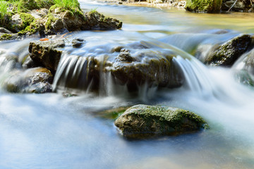 Fototapeta na wymiar Idyllischer Wasserfall mit Stein und Fels