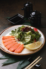 Fried slices of salmon with lettuce and sauce