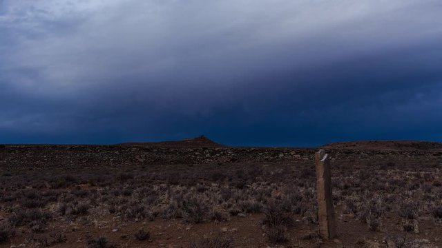 A dramatic static timelapse of old abstract, historical rock fence poles with dark stormy clouds rolling through the sky in a Karoo landscape
