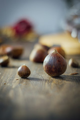 Big chestnut and small one on wooden table. Raw and organic vegan chestnuts. Variety of size.