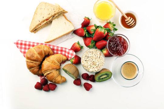breakfast on table with sandwiches, croissants, coffe and juice