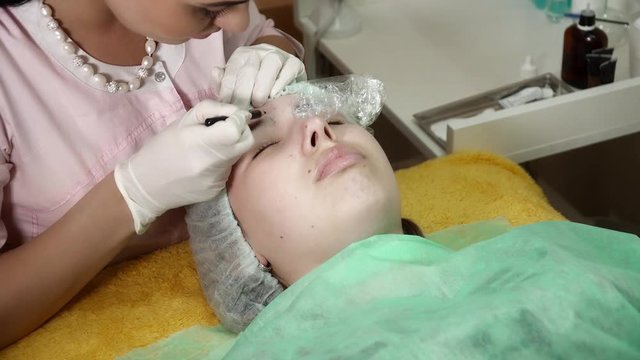 Beautician is making a microblading brocedure