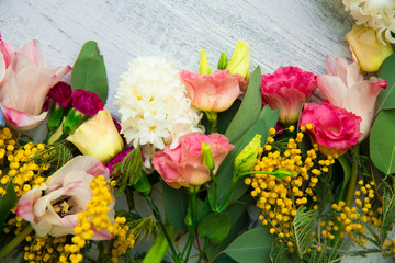 Spring flowers on wood background. Summer blooming border on a wooden table.