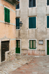 Fototapeta na wymiar Green window shutters. The facade of houses in Montenegro.