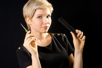 Fototapeta premium Young cute girl hairdresser with scissors