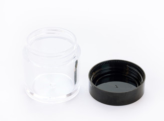Empty small plastic or glass jar with black lid on white background