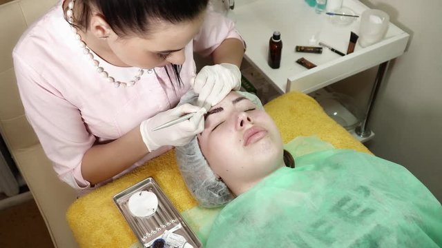 Cosmetologist is making a microblading procedure in beauty salon
