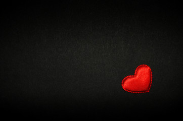 Red heart isolated on black paper. Love concept. Top view.