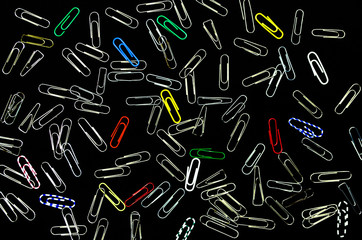 Paper clips isolated on black background. Office paper work concept background. Top view.