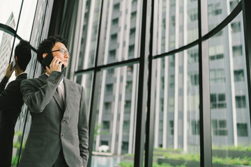 Asian businessman or entrepreneur using mobile phone, business or communication technology concept, with copy space