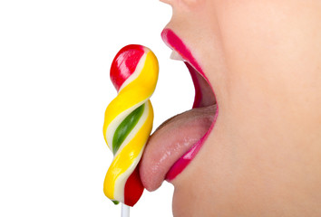 Naklejka premium Young beautiful woman holds multi-colored candy. Girl bites candy. Lollipop