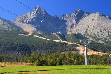 Lomnicky and Kezmarsky peaks High Tatras, Tatra National Park, Slovakia in sunny autumn day with ski slopes without snow and with various cable cars, seen from Tatranska Lomnica