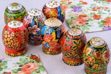 Close-up Easter eggs with bright lacquer paintings on a background of natural tablecloths and coloured serviettes