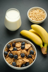 Healthy food. Milk, multi grain flakes with blueberry, nuts and bananas for breakfast.