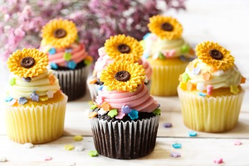 Spring Summer Cupcakes with edible sunflowers and buttercream frosting, selective focus