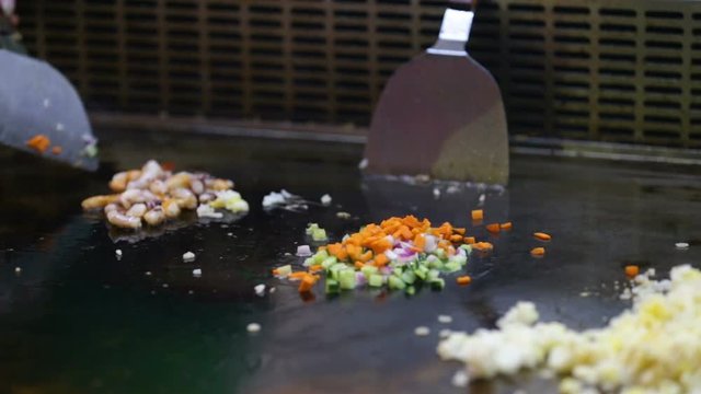 Cooking shrimp with vegetables and rice on a hot surface