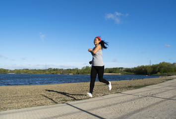 Fototapeta na wymiar Asian Female Jogging Around Lake