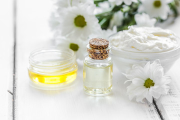 natural essential aroma oil with camomile on wooden table background