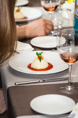 mini round cheesecake with strawberry jam on a plate in the expensive restaurant. close view